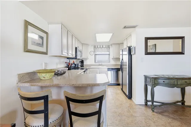 a kitchen with kitchen island a stove a table and chairs