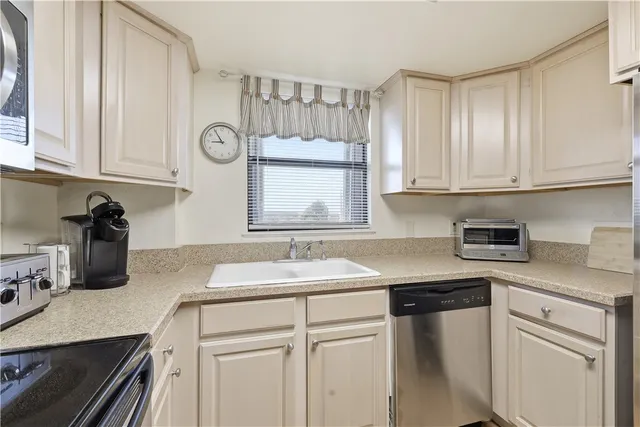 a kitchen with granite countertop a sink a stove and cabinets