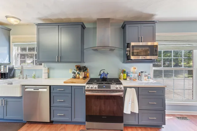a kitchen with granite countertop a stove a microwave a sink and cabinets