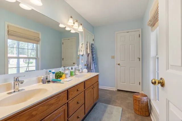 a bathroom with a sink double vanity granite tub and a mirror