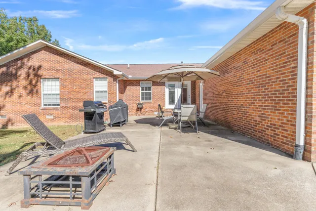 a view of a patio with couches table and chairs and potted plants