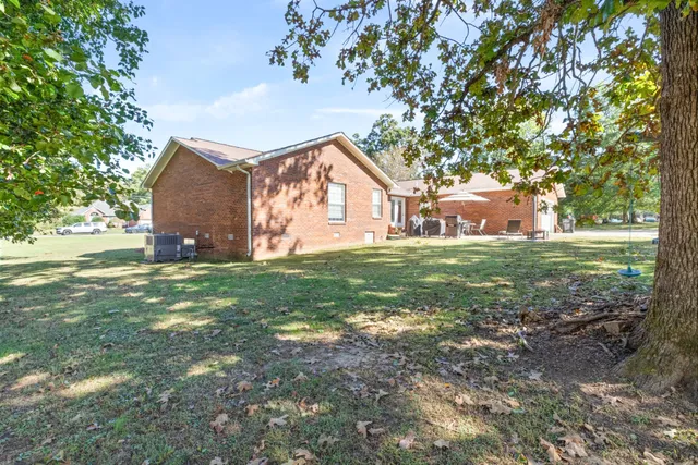 a view of a house with yard and a tree