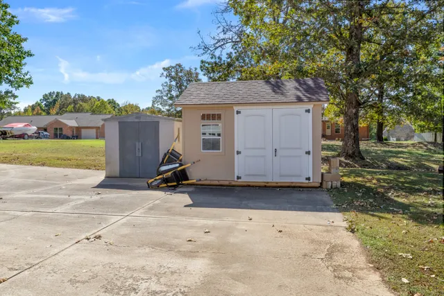 a view of backyard with barbeque grill and wooden fence