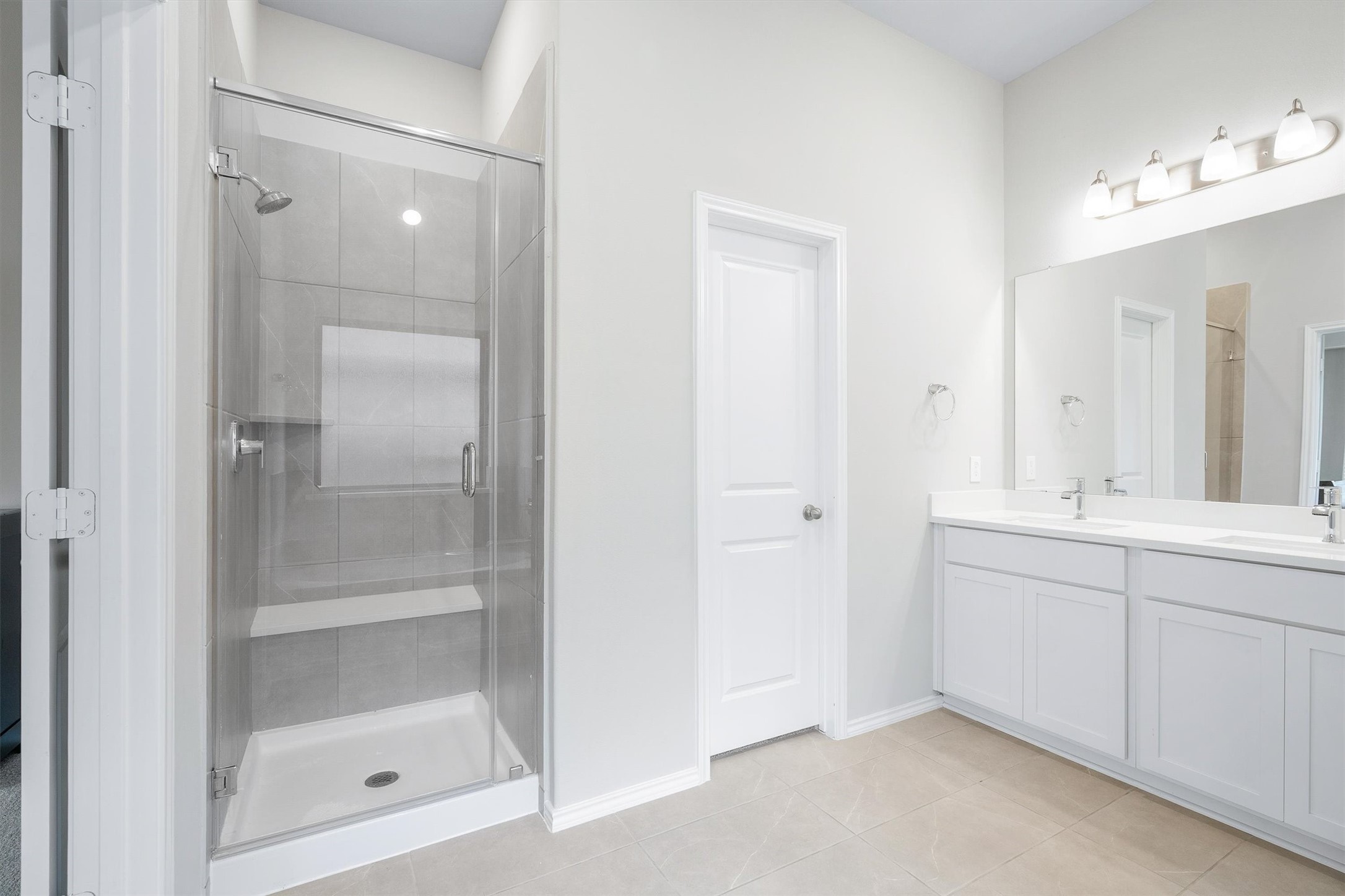 17270 Wild Watermelon Way Conroe, TX 77302 - Photo 16 of 28 And there is the walk-in shower. Glass door, tiled walls, and a built-in bench, paired with the double vanity and soaking tub from the other side. The primary bath truly has it all.