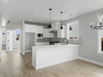 a large white kitchen with stainless steel appliances