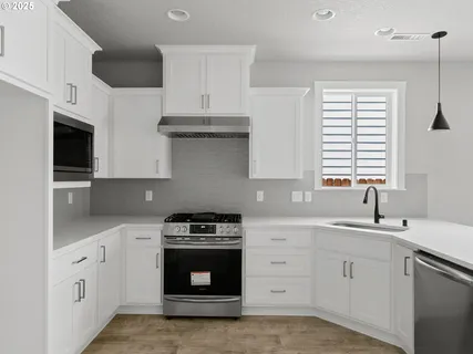 a kitchen with cabinets appliances a sink and a window