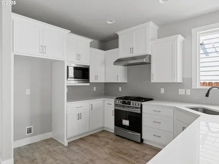 a kitchen with stainless steel appliances a stove a sink and a microwave