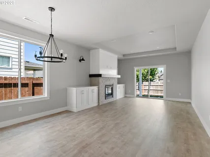 a view of a room with wooden floor fireplace and windows