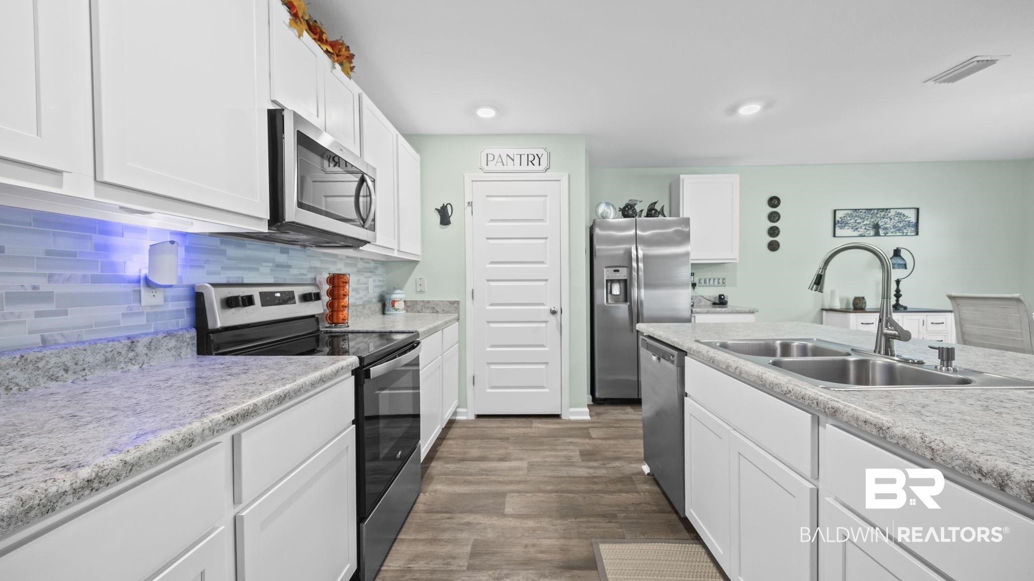 349 Hartenstein Road Foley, AL 36535 - Photo 18 of 32 Kitchen with stainless steel appliances, white cabinets, decorative backsplash, light countertops, and dark wood-style floors