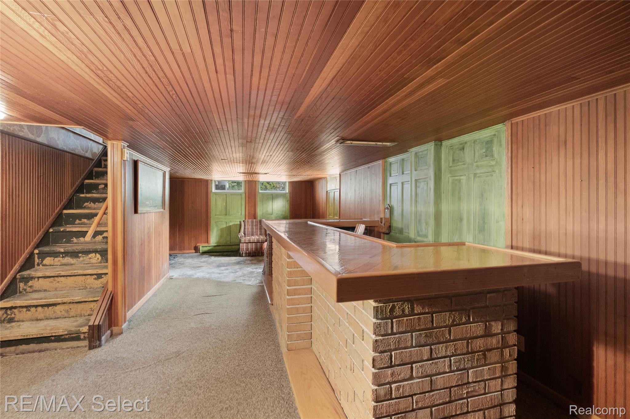 11080 Lapeer Road Davison, MI 48423 - Photo 52 of 64 Wood-paneled ceiling, wood-paneled walls, brick-faced bar, integrated cabinetry, and built-in stairs
