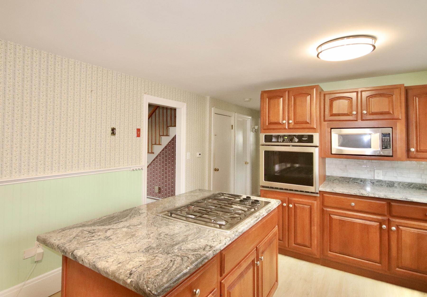 46 Fisher Road Hyannis, MA 02601 - Photo 8 of 29 a kitchen with granite countertop a stove a sink and a microwave