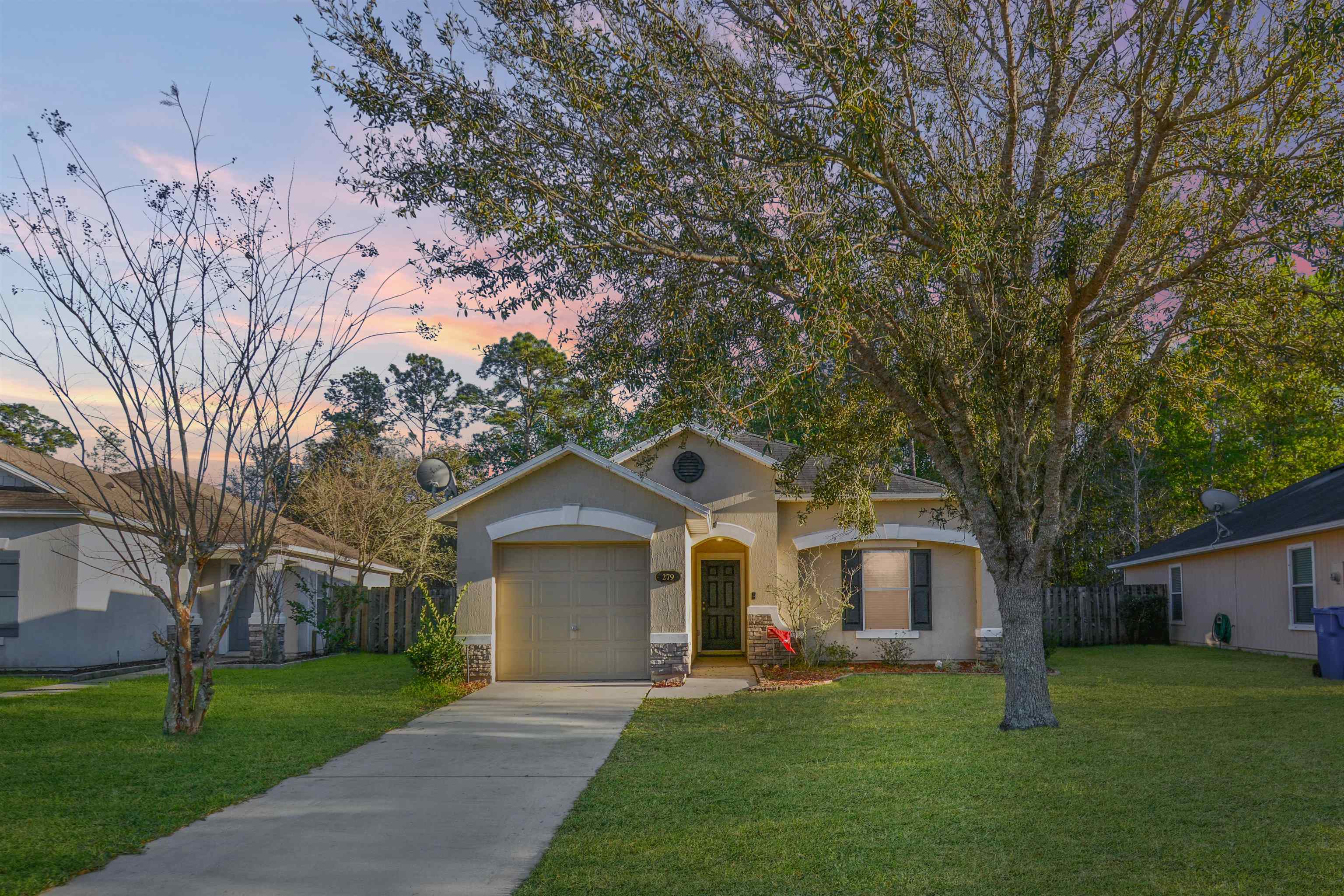 279 Buck Run Way St. Augustine, FL 32092 - Photo 1 of 28 a front view of a house with a garden and trees