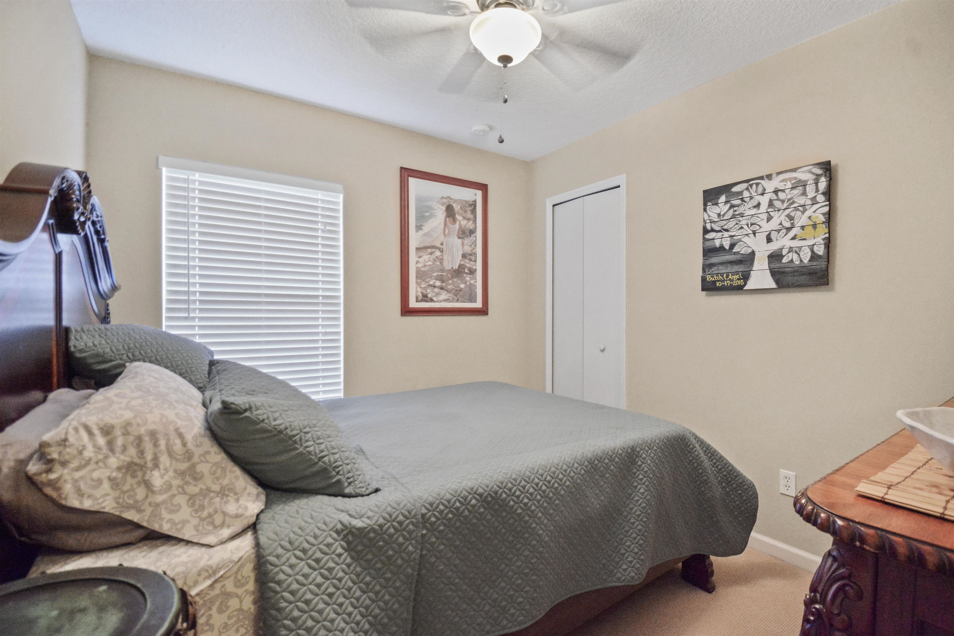 279 Buck Run Way St. Augustine, FL 32092 - Photo 17 of 28 a bedroom with a bed and a chandelier