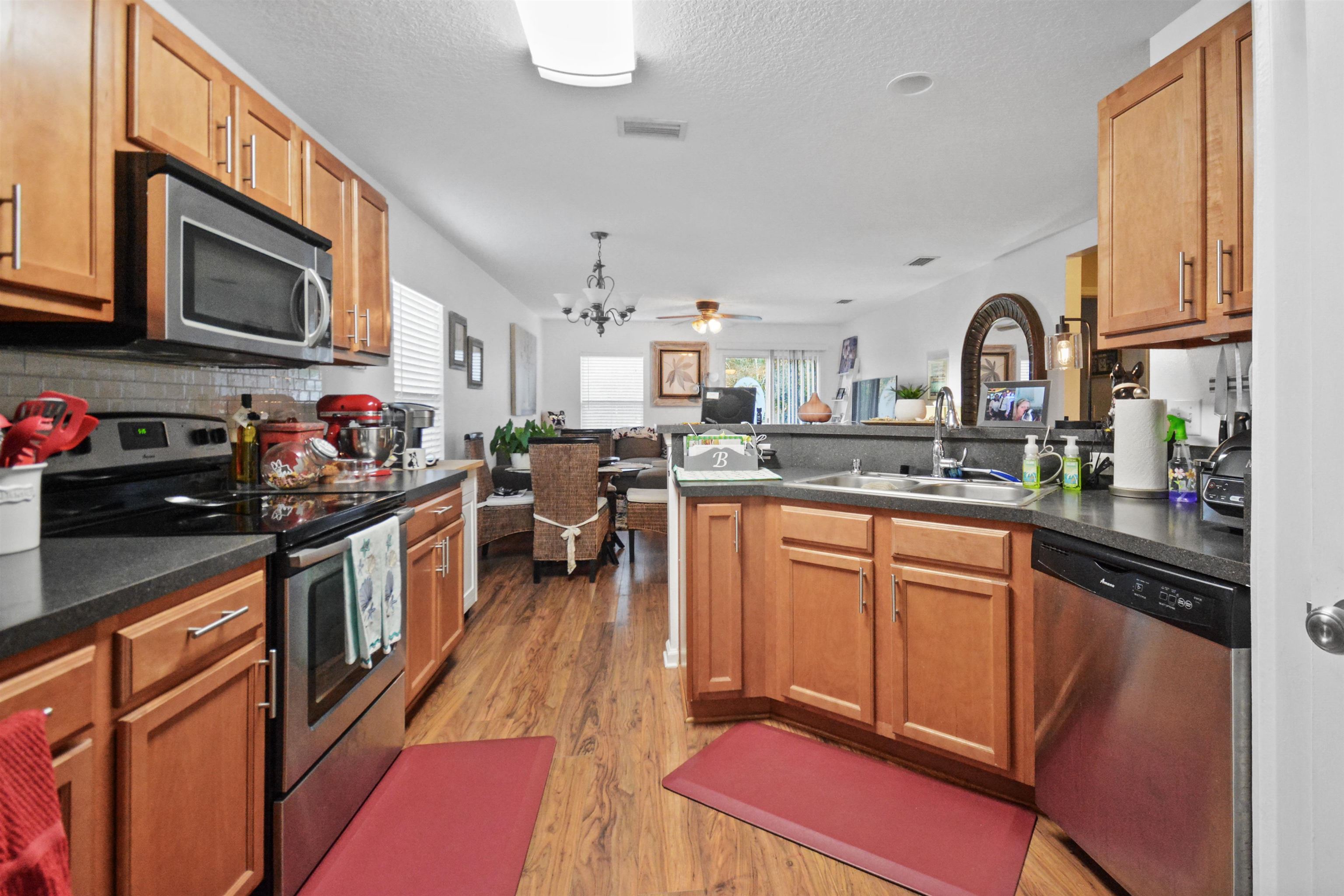 279 Buck Run Way St. Augustine, FL 32092 - Photo 9 of 28 a kitchen with stainless steel appliances granite countertop a stove top oven a sink dishwasher and a microwave oven with cabinets