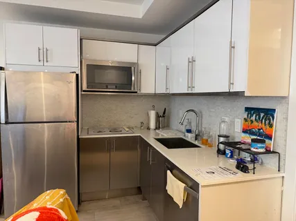 a kitchen with a sink a refrigerator and cabinets