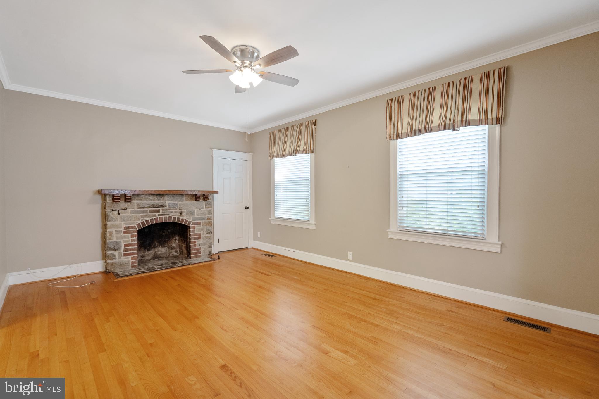 1955 Seminary Road Silver Spring, MD 20910 - Photo 7 of 41 a view of an empty room with chandelier fan and a fireplace