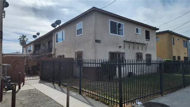 a view of a brick house with wooden fence