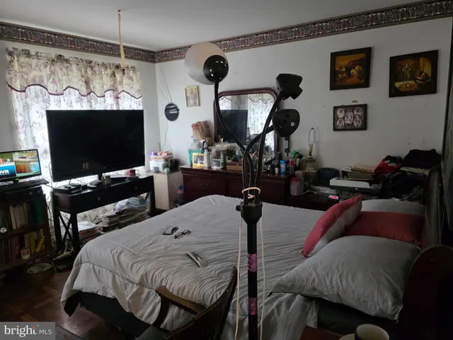 a living room with furniture a flat screen tv and kitchen view