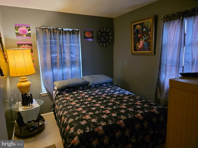 a bedroom with a bed and a lamp on the dresser