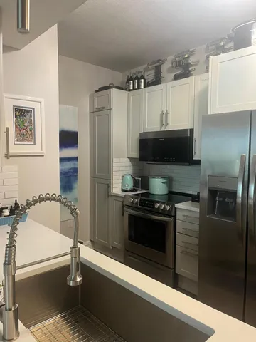 a kitchen with stainless steel appliances a refrigerator a stove and a refrigerator