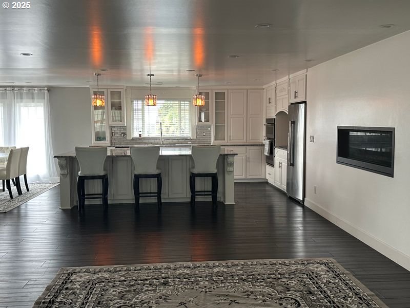 711 1st Street Brookings, OR 97415 - Photo 5 of 21 a kitchen with stainless steel appliances granite countertop a table chairs refrigerator and sink