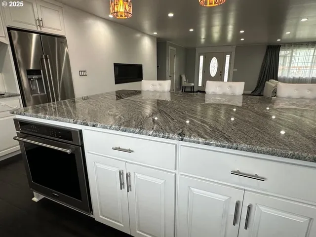 a kitchen with kitchen island granite countertop counter top space cabinets and stainless steel appliances