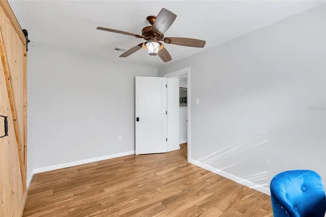 a view of a room with wooden floor and ceiling fan