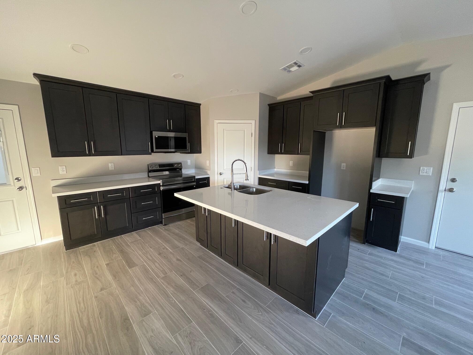 82 West Brooks Street Gilbert, AZ 85233 - Photo 3 of 23 a kitchen with stainless steel appliances a refrigerator a sink a stove a microwave and wooden floors