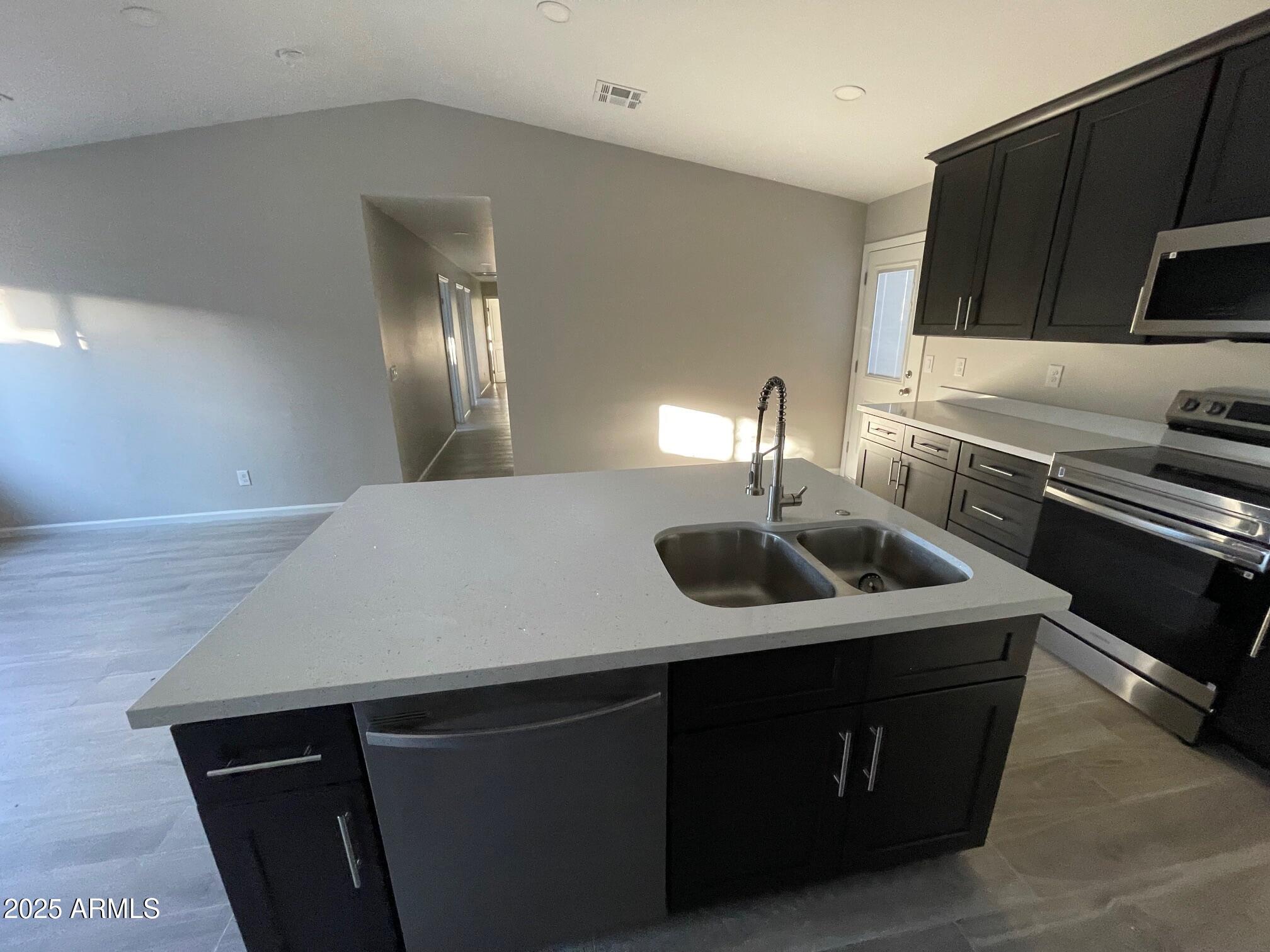 82 West Brooks Street Gilbert, AZ 85233 - Photo 6 of 23 a kitchen with a sink a stove a microwave and refrigerator