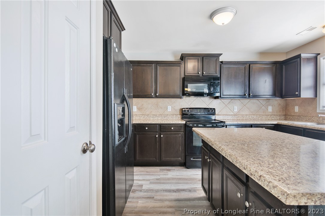 2040 Yellowbrick Road Fayetteville, NC 28314 - Photo 17 of 50 a kitchen with stainless steel appliances granite countertop a stove a sink and a refrigerator