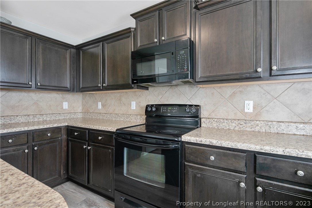 2040 Yellowbrick Road Fayetteville, NC 28314 - Photo 21 of 50 a kitchen with granite countertop cabinets stove and microwave