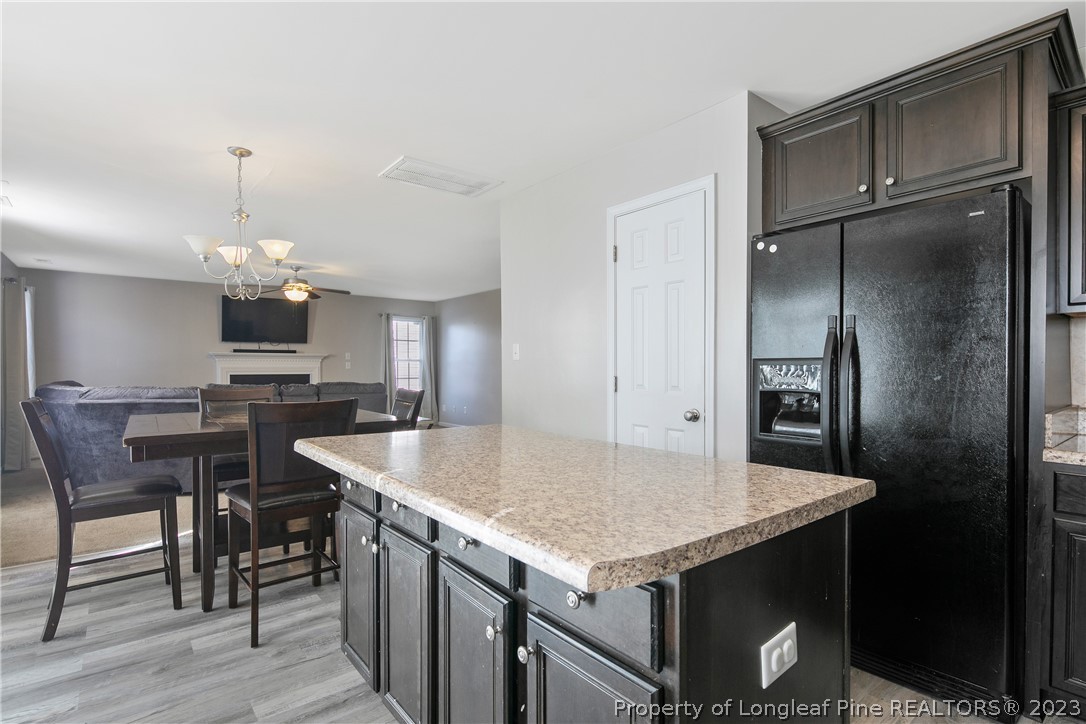 2040 Yellowbrick Road Fayetteville, NC 28314 - Photo 22 of 50 a kitchen with a stove a refrigerator and a dining table
