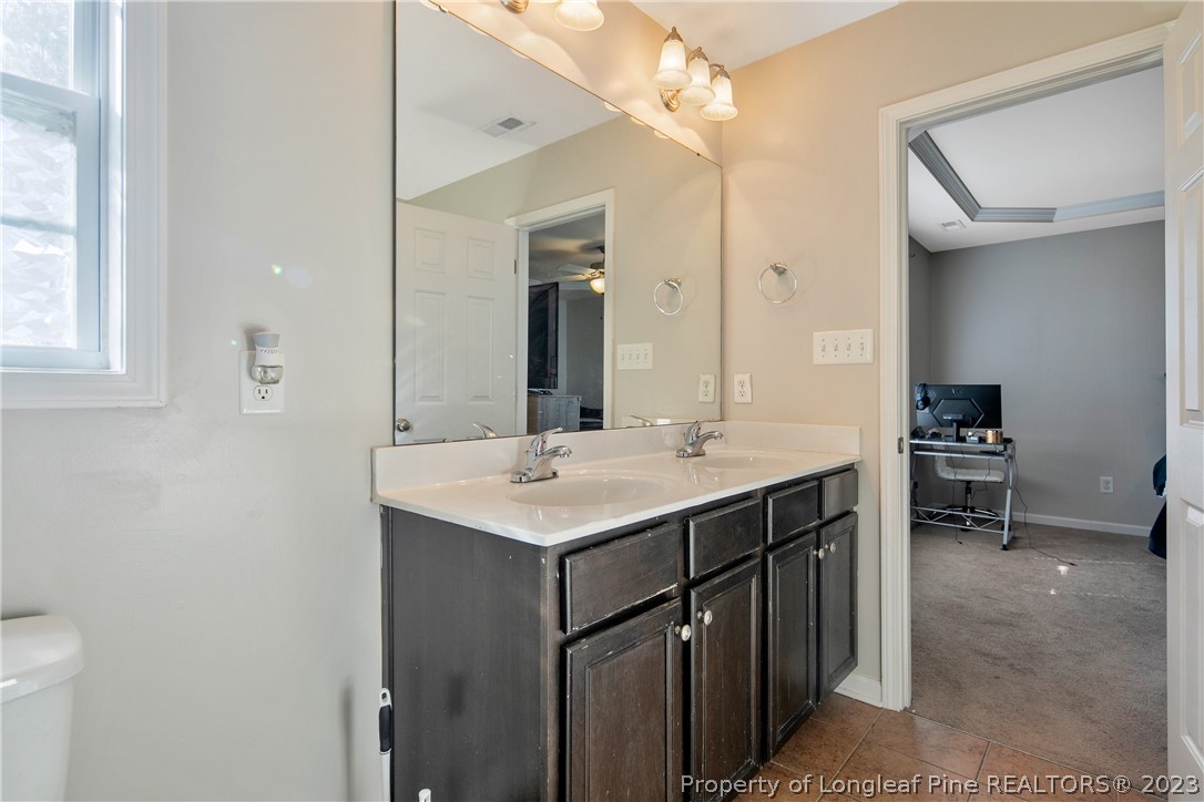 2040 Yellowbrick Road Fayetteville, NC 28314 - Photo 34 of 50 a bathroom with a sink a toilet a mirror and shower
