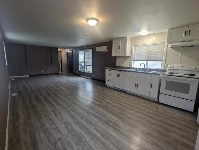 a large kitchen with wooden floors and stainless steel appliances