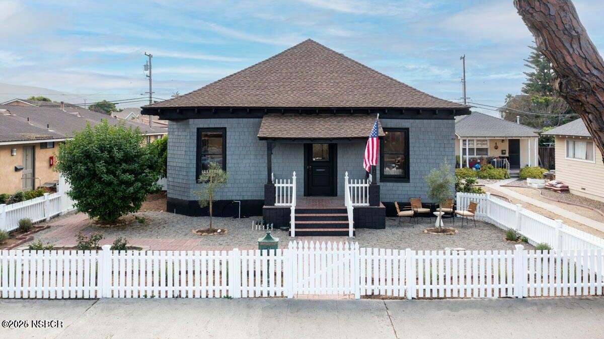 a view of a house with a small yard and wooden fence