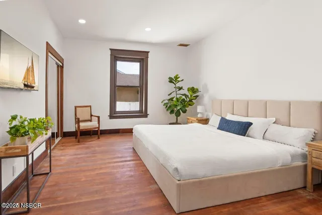 a bedroom with a bed and a potted plant