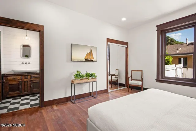 a bedroom with a bed and dresser with mirror