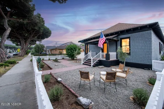 a view of a house with backyard and sitting area