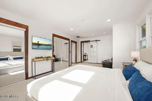 a large bedroom with a large bed and a large mirror