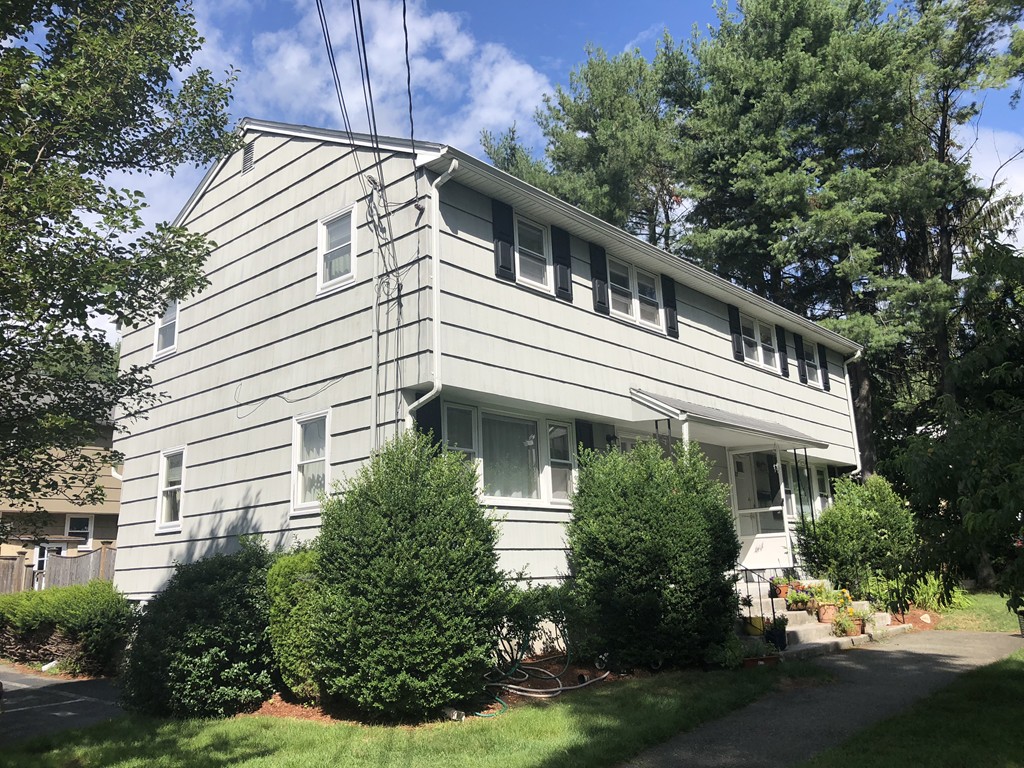 27 George Road, Unit 27 Winchester, MA 01890 - Photo 1 of 30 a house with lots of trees in the background