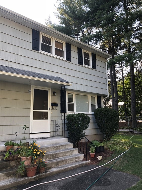 27 George Road, Unit 27 Winchester, MA 01890 - Photo 2 of 30 a front view of a house with potted plants