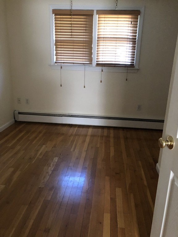 27 George Road, Unit 27 Winchester, MA 01890 - Photo 8 of 30 a view of an empty room with wooden floor and a window