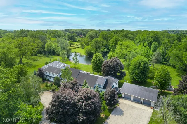 an aerial view of green landscape with trees houses and mountain view