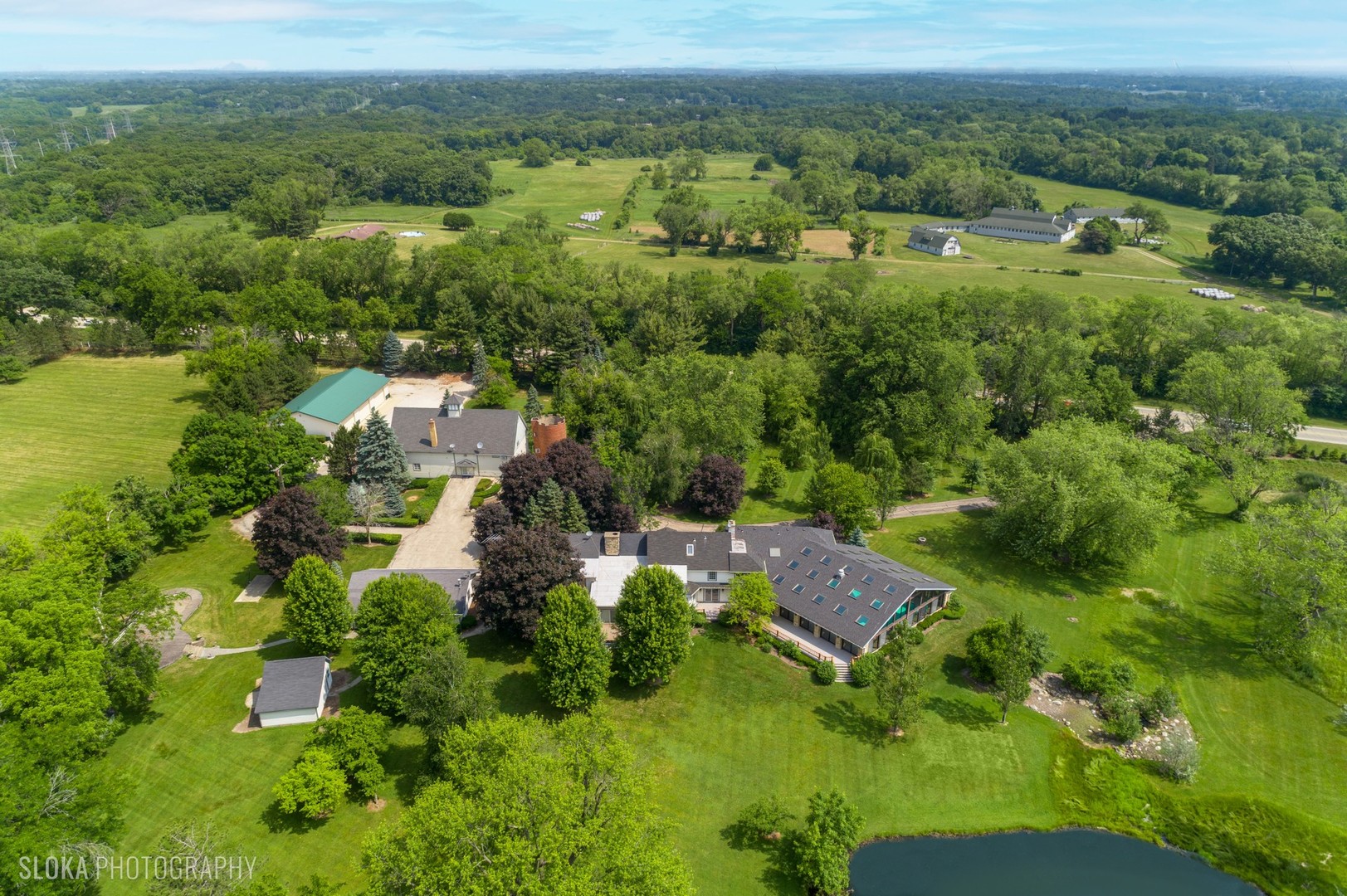 153 Algonquin Road Barrington Hills, IL 60010 - Photo 2 of 95 an aerial view of green landscape with trees houses and mountain view