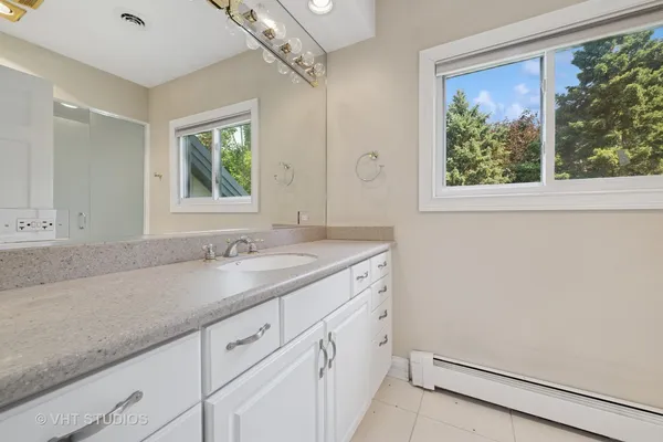 a bathroom with a sink a mirror a vanity and a shower