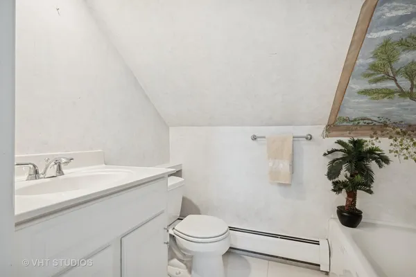 a view of a white house with a yard and potted plants