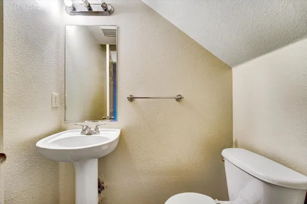 a bathroom with a sink mirror and toilet