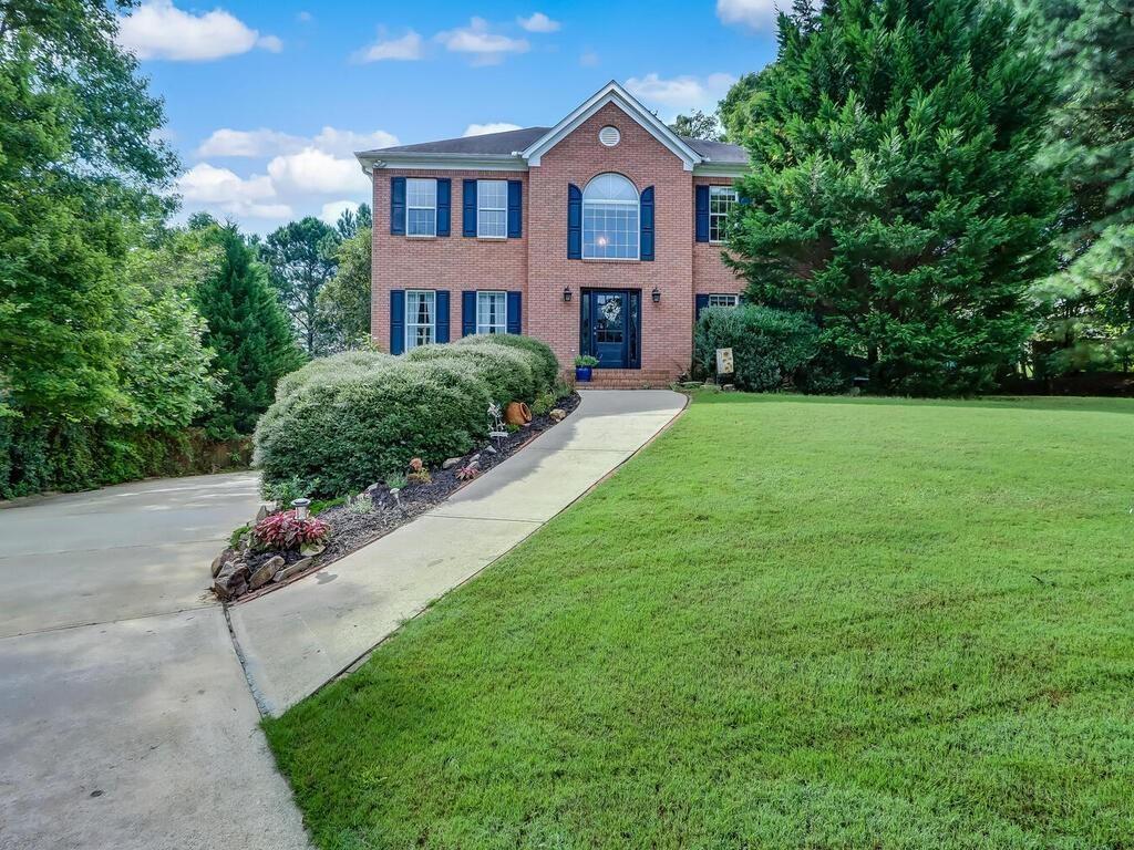 a front view of a house with a garden