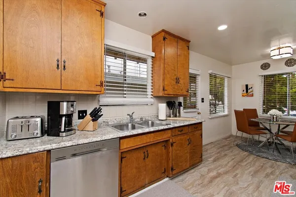 a kitchen with sink a window and chairs