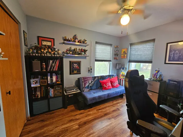 a living room with furniture a rug and a bookshelf